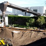 Conveyor shifting soil onto property