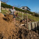 Digging hillside in preparation for retaining wall construction